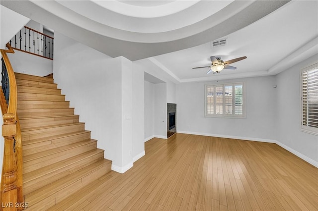 2432 Granada Bluff Ct, Las Vegas, NV 89135 - unfurnished living room featuring a raised ceiling, a fireplace, baseboards, and a ceiling fan