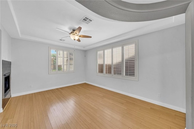 2432 Granada Bluff Ct, Las Vegas, NV 89135 - empty room with a tray ceiling, baseboards, a ceiling fan, and light wood finished floors