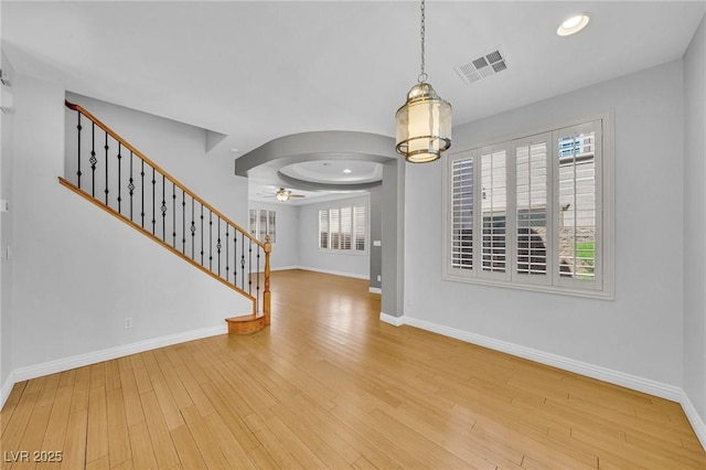 2432 Granada Bluff Ct, Las Vegas, NV 89135 - unfurnished dining area with stairway, a ceiling fan, baseboards, wood finished floors, and a chandelier