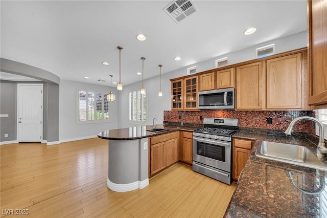2432 Granada Bluff Ct, Las Vegas, NV 89135 - kitchen featuring appliances with stainless steel finishes, a sink, a peninsula, glass insert cabinets, and recessed lighting