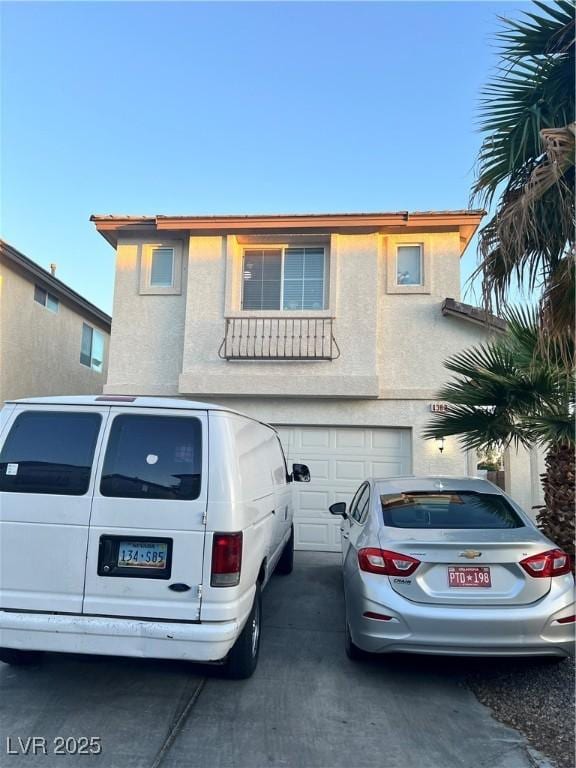view of front of home featuring a garage, driveway, and stucco siding