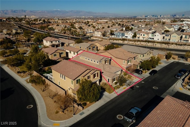 aerial view of residential area with property parcel outlined and a mountain backdrop