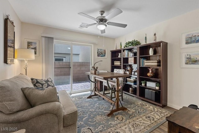 home office featuring wood finished floors, a ceiling fan, and baseboards