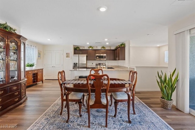 dining room with light wood-style flooring, baseboards, and recessed lighting