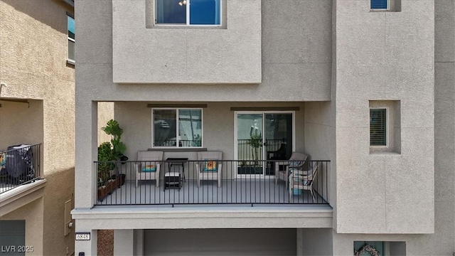back of house with a balcony and stucco siding