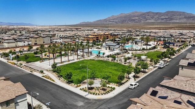 aerial perspective of suburban area featuring a mountainous background and a pool area