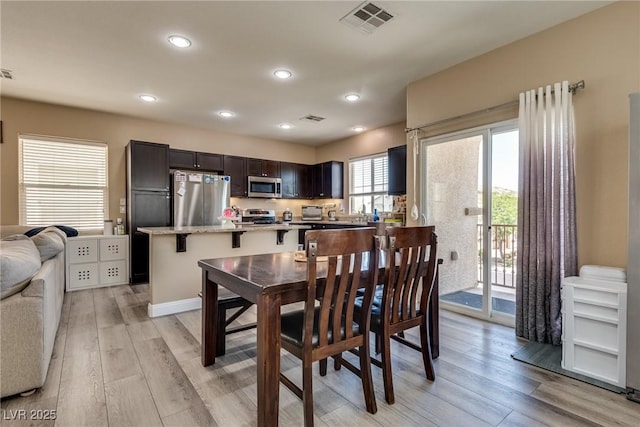 dining space with light wood-style flooring and recessed lighting
