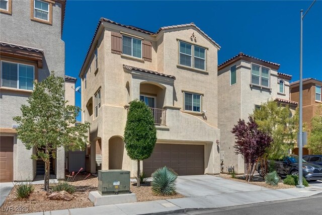 view of front of home with stucco siding, a tile roof, an attached garage, and driveway
