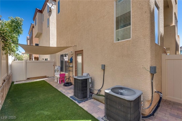 rear view of house featuring central air condition unit and stucco siding