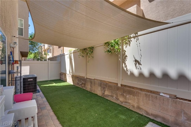 view of yard with fence and central AC