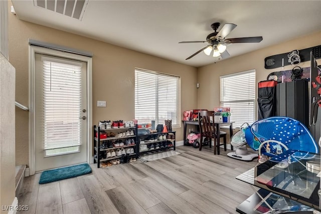 game room with wood finished floors, a ceiling fan, plenty of natural light, and baseboards