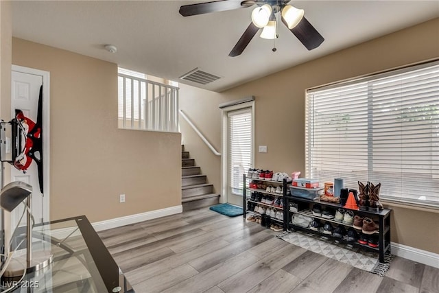 recreation room featuring wood finished floors, ceiling fan, and baseboards