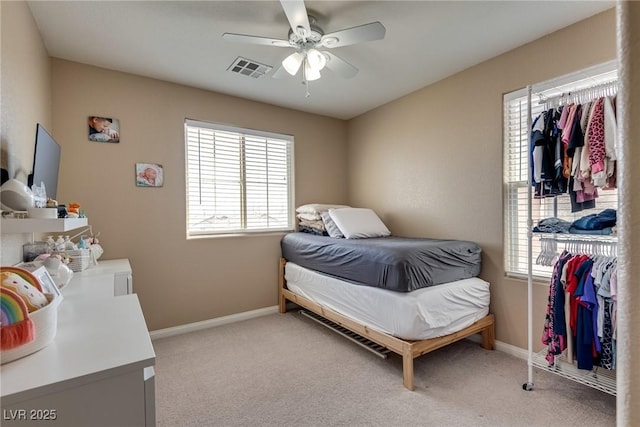 bedroom with multiple windows, light colored carpet, and baseboards