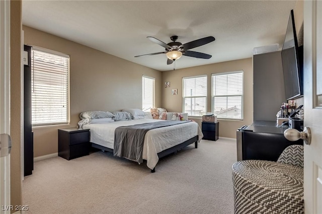 bedroom featuring light carpet, baseboards, and ceiling fan