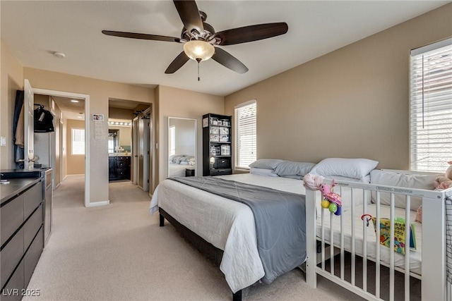 bedroom featuring light carpet, multiple windows, and a ceiling fan