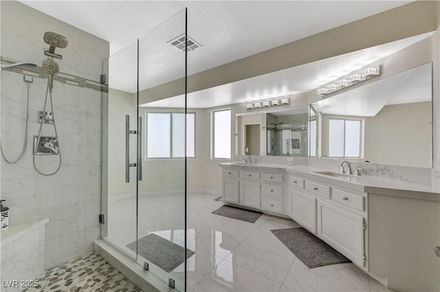4 Tarryall Ter, Henderson, NV 89074 - bathroom featuring a marble finish shower, double vanity, plenty of natural light, and marble look tiles