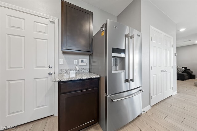 3854 Stadium Ave, Las Vegas, NV 89120 - kitchen featuring stainless steel fridge with ice dispenser, dark brown cabinets, light stone countertops, light wood finished floors, and recessed lighting