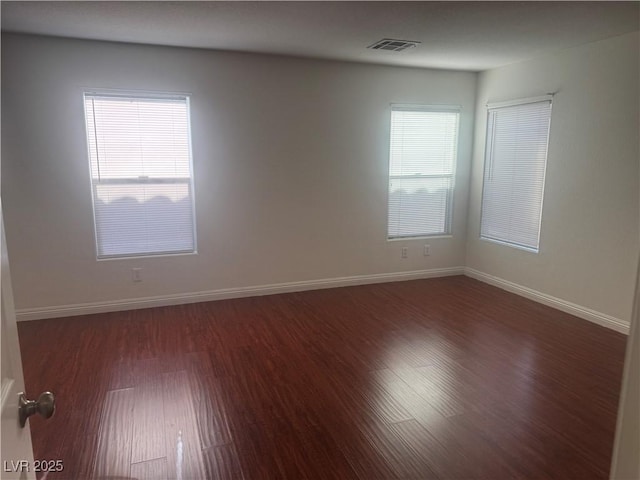 unfurnished room with wood finished floors and baseboards