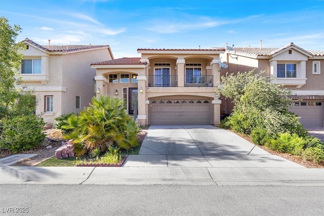 mediterranean / spanish home with a balcony, stucco siding, a garage, driveway, and a tile roof