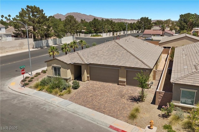 3706 Etendre Ct, Las Vegas, NV 89121 - view of front of house with stucco siding, a mountain view, an attached garage, driveway, and a tiled roof