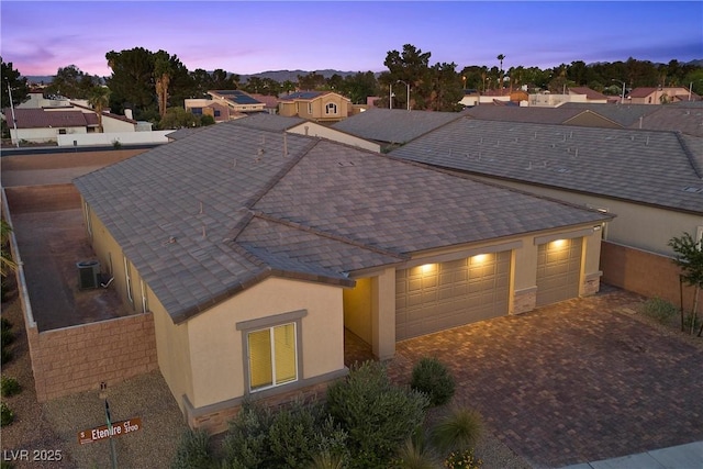 3706 Etendre Ct, Las Vegas, NV 89121 - view of front of home featuring a garage, stucco siding, decorative driveway, and roof with shingles