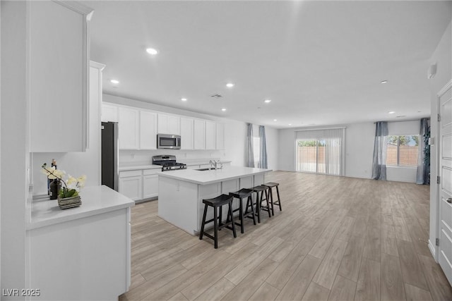 3706 Etendre Ct, Las Vegas, NV 89121 - kitchen with stainless steel appliances, a sink, light wood finished floors, open floor plan, and recessed lighting