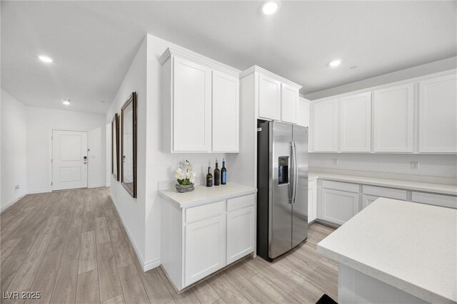 3706 Etendre Ct, Las Vegas, NV 89121 - kitchen featuring stainless steel fridge with ice dispenser, light countertops, white cabinets, light wood-style flooring, and recessed lighting