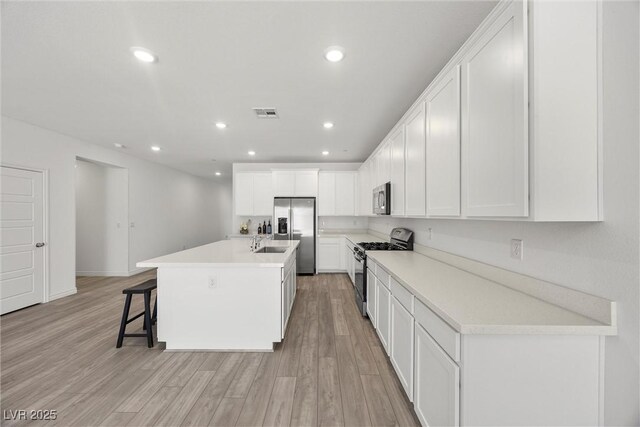 3706 Etendre Ct, Las Vegas, NV 89121 - kitchen with appliances with stainless steel finishes, light wood-style floors, white cabinets, and recessed lighting