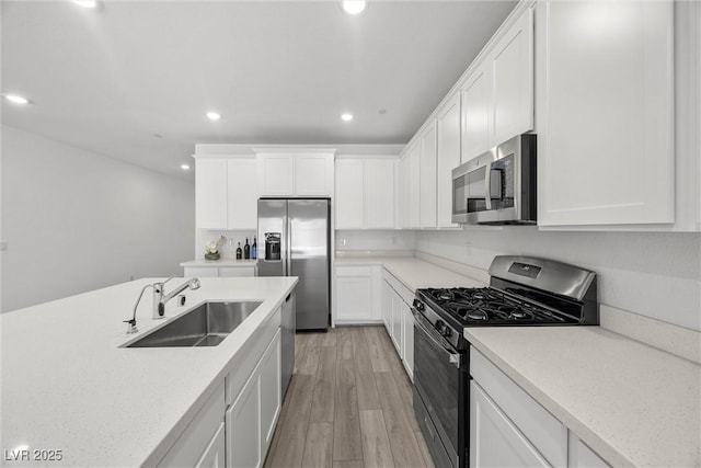 3706 Etendre Ct, Las Vegas, NV 89121 - kitchen with appliances with stainless steel finishes, a sink, recessed lighting, light wood-style flooring, and white cabinetry