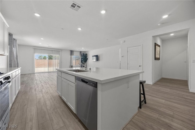 3706 Etendre Ct, Las Vegas, NV 89121 - kitchen with dishwasher, a sink, light wood-style floors, a kitchen island with sink, and white cabinets