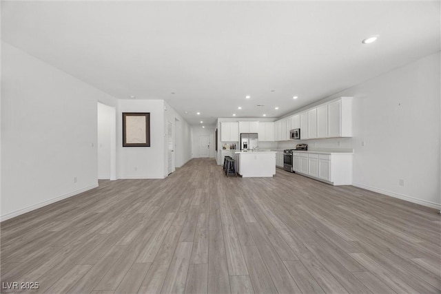 3706 Etendre Ct, Las Vegas, NV 89121 - unfurnished living room with light wood-type flooring, recessed lighting, and baseboards