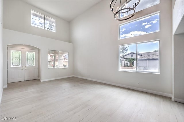3065 Blue Monaco St, Las Vegas, NV 89117 - foyer featuring a towering ceiling, a chandelier, healthy amount of natural light, french doors, and wood finished floors