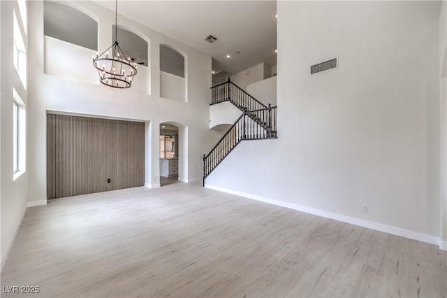 3065 Blue Monaco St, Las Vegas, NV 89117 - entryway featuring stairs, a chandelier, wood finished floors, arched walkways, and a high ceiling