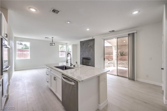 3065 Blue Monaco St, Las Vegas, NV 89117 - kitchen featuring stainless steel dishwasher, a fireplace, white cabinetry, light wood-style floors, and recessed lighting