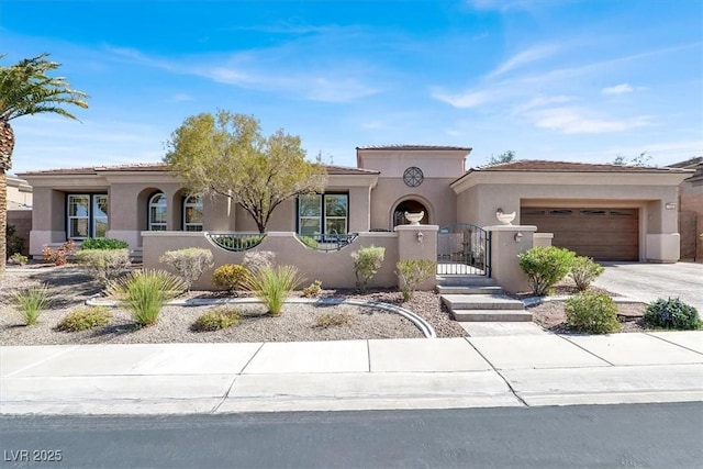 mediterranean / spanish house featuring stucco siding, an attached garage, a fenced front yard, and concrete driveway