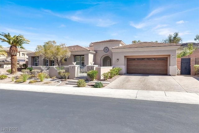 mediterranean / spanish house featuring stucco siding, a gate, driveway, a garage, and fence