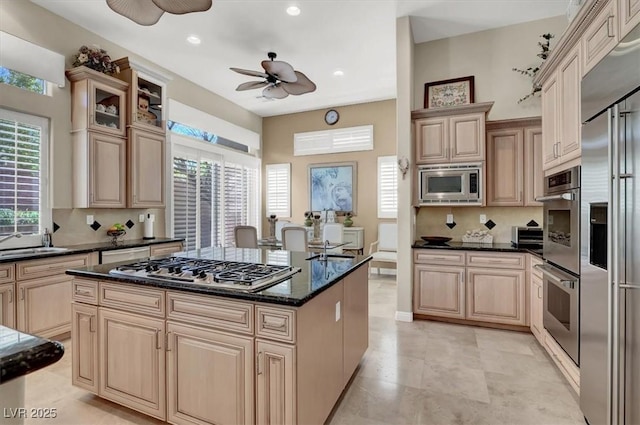 kitchen with built in appliances, a ceiling fan, a sink, healthy amount of natural light, and recessed lighting