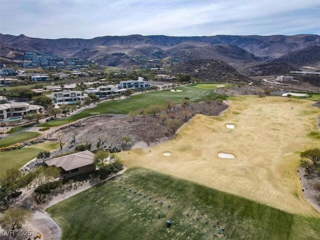 aerial view of property and surrounding area featuring a mountainous background and a local golf course