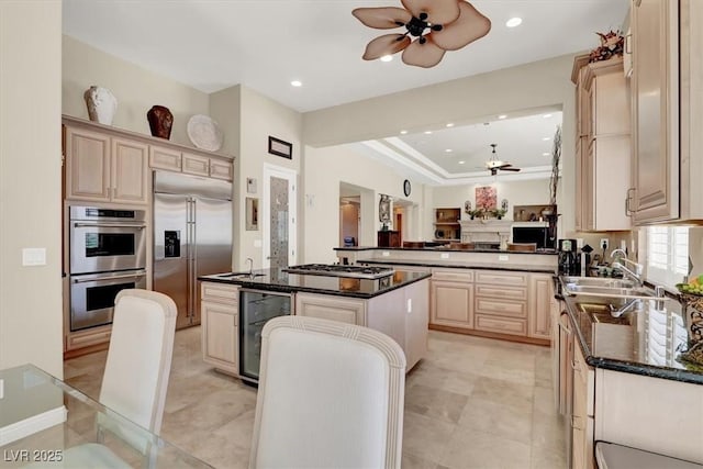kitchen with a ceiling fan, appliances with stainless steel finishes, a kitchen island, recessed lighting, and wine cooler
