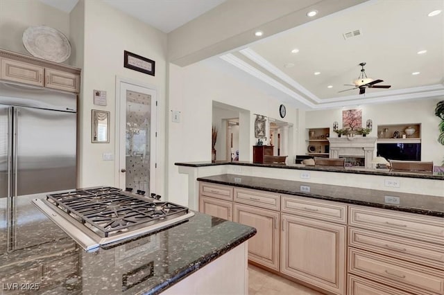 kitchen with appliances with stainless steel finishes, dark stone counters, a ceiling fan, open floor plan, and recessed lighting