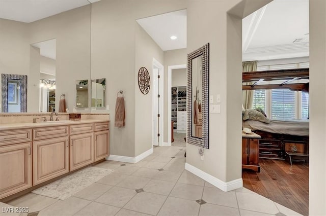 full bathroom featuring baseboards, vanity, tile patterned flooring, and a walk in closet