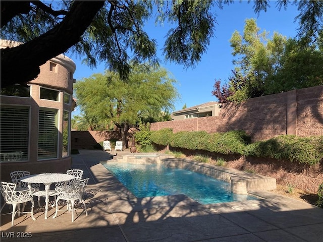 view of swimming pool featuring a patio, a fenced backyard, and a pool with connected hot tub