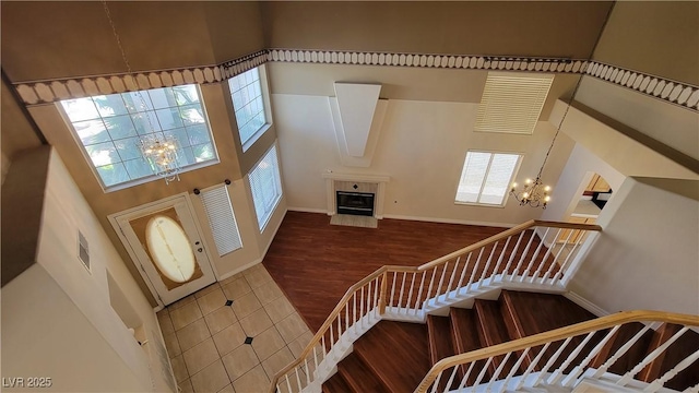 1211 Silver Knoll Ave, Las Vegas, NV 89123 - entryway featuring a chandelier, stairs, a high ceiling, wood finished floors, and a tiled fireplace