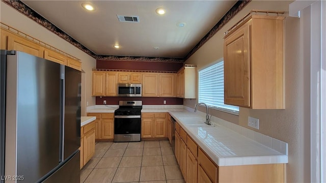 1211 Silver Knoll Ave, Las Vegas, NV 89123 - kitchen with stainless steel appliances, a sink, light brown cabinets, light tile patterned flooring, and recessed lighting