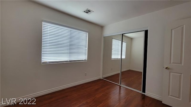 1211 Silver Knoll Ave, Las Vegas, NV 89123 - unfurnished bedroom with dark wood finished floors, a closet, and baseboards