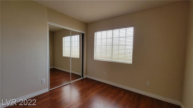 1211 Silver Knoll Ave, Las Vegas, NV 89123 - unfurnished bedroom featuring baseboards, dark wood-style flooring, and a closet