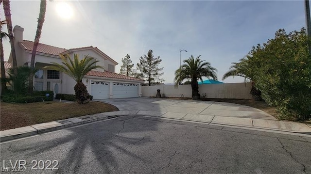 1211 Silver Knoll Ave, Las Vegas, NV 89123 - view of front of house with concrete driveway, a tiled roof, fence, an attached garage, and stucco siding