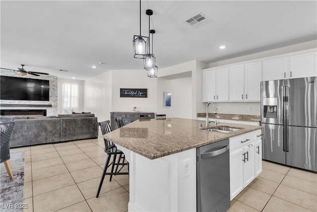7545 Fontera Ct, Las Vegas, NV 89139 - kitchen with stainless steel appliances, a sink, light tile patterned flooring, dark stone countertops, and white cabinetry