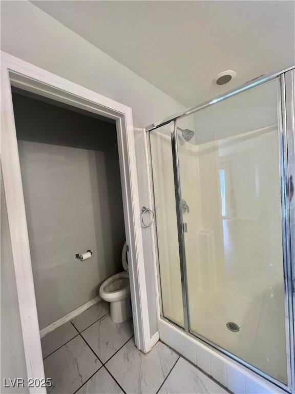 6545 Netherseal Ave, Las Vegas, NV 89139 - full bath with marble finish floors, a stall shower, baseboards, and toilet