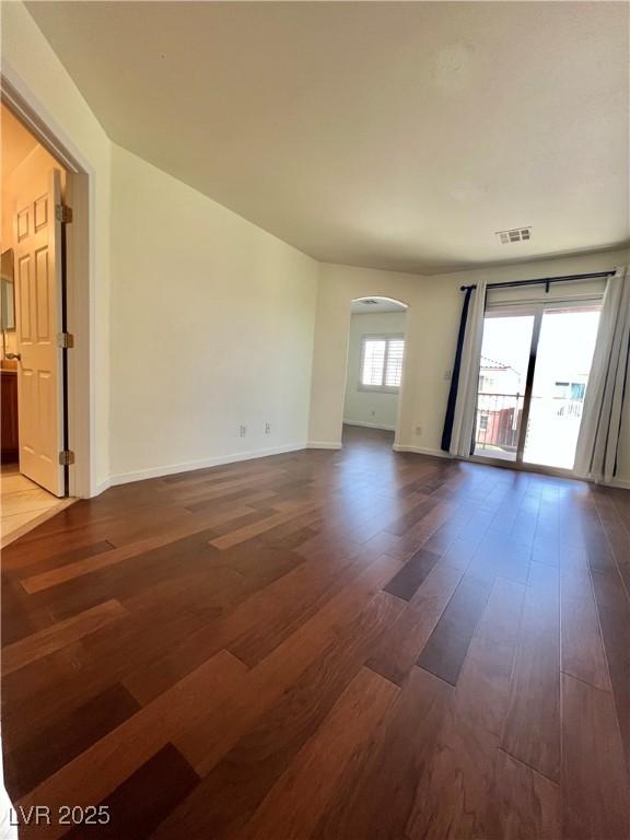 6545 Netherseal Ave, Las Vegas, NV 89139 - unfurnished room featuring arched walkways, dark wood-type flooring, and baseboards